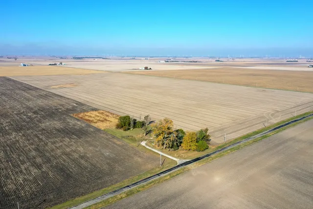 an empty room with wooden floor & windows
