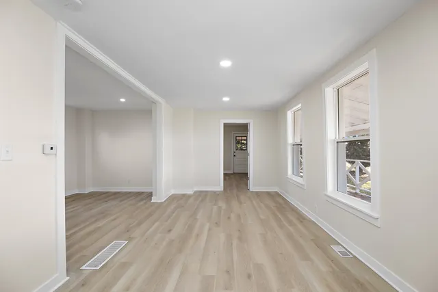 a view of an empty room with wooden floor