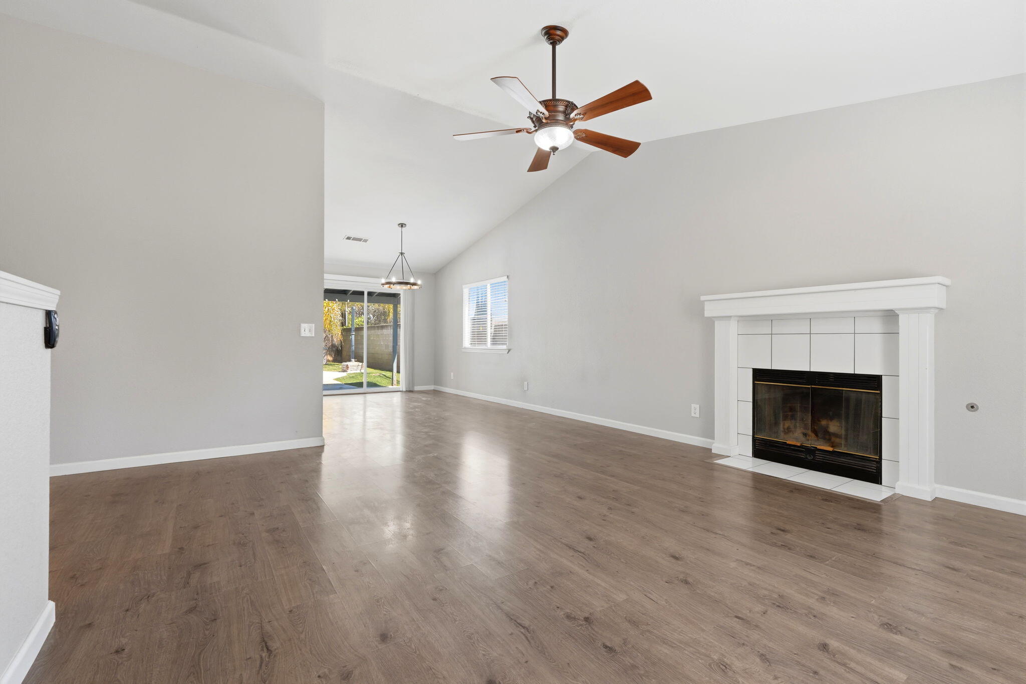 481 Katelyn Court Exeter, CA 93221 - Photo 8 of 33 a view of an empty room with wooden floor fireplace and a window
