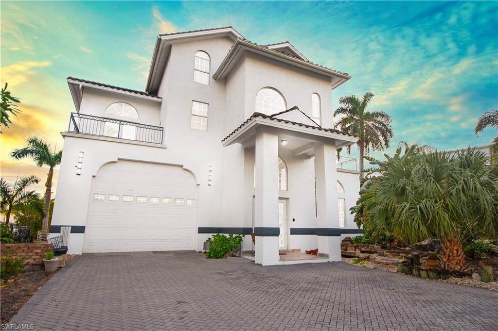 28 West Pelican Street Naples, FL 34113 - Photo 2 of 50 a view of a white house with a small yard and plants