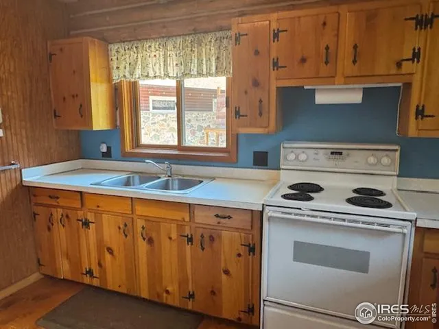 a kitchen with granite countertop a sink a stove and cabinets