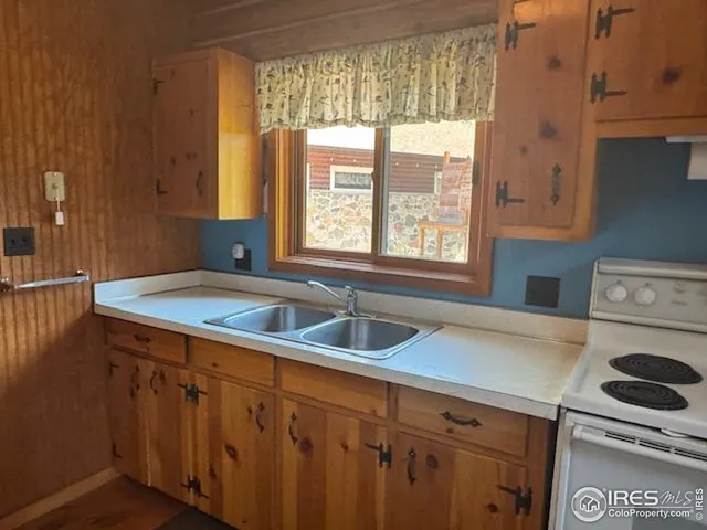 a kitchen with granite countertop a sink and a stove