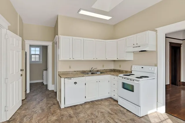 a kitchen with granite countertop white cabinets and white appliances