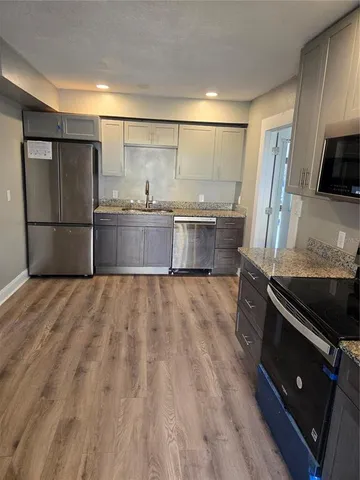 a kitchen with stainless steel appliances granite countertop a stove a microwave and a refrigerator