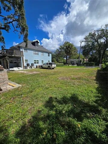 a view of a big yard with a house in the background