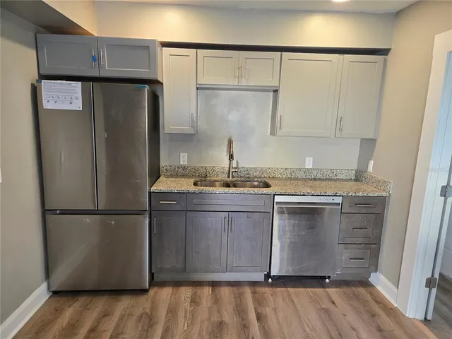 a kitchen with granite countertop a refrigerator and a sink