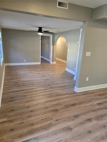 a view of empty room with wooden floor