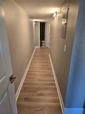 a view of a hallway with wooden floor and staircase