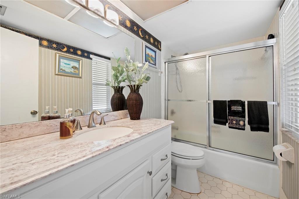 740 Teryl Road, Unit 1 Naples, FL 34112 - Photo 17 of 21 a bathroom with a granite countertop sink a toilet and shower