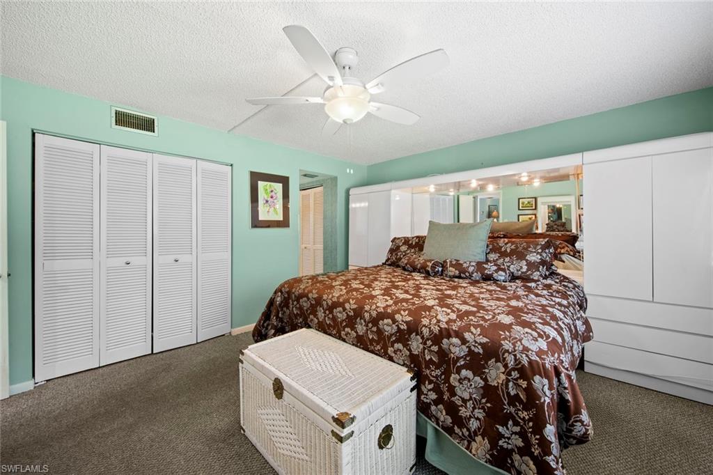 740 Teryl Road, Unit 1 Naples, FL 34112 - Photo 19 of 21 a bed room with a bed and a chandelier