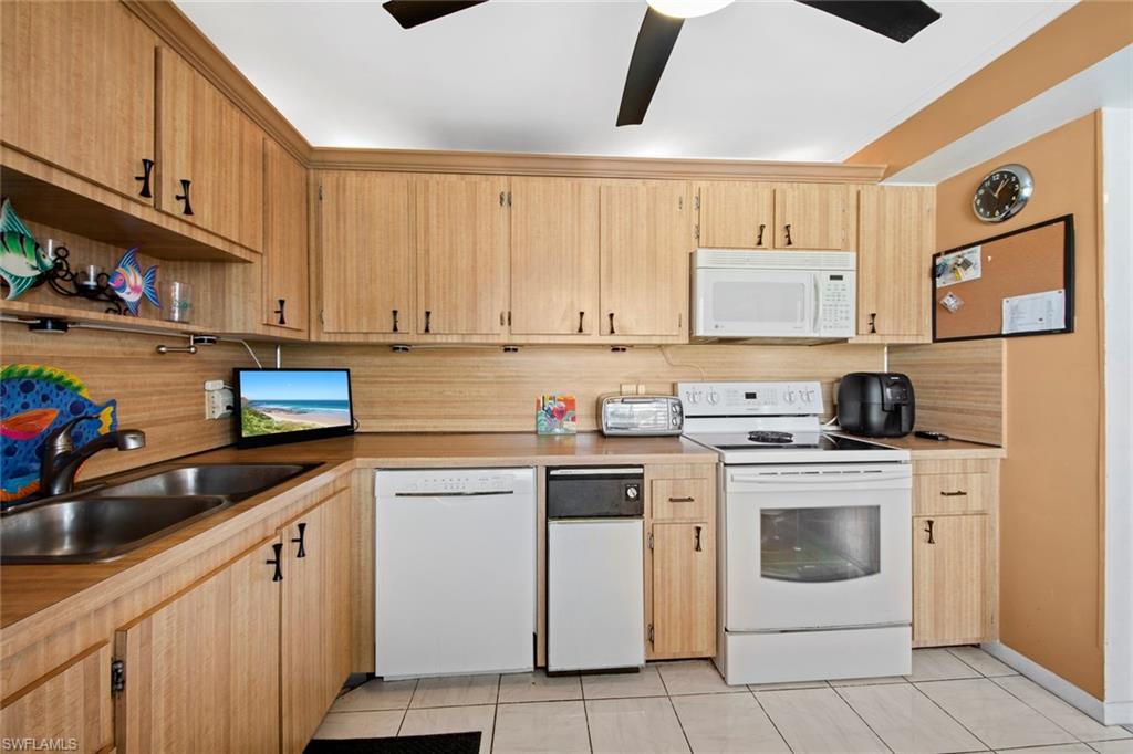740 Teryl Road, Unit 1 Naples, FL 34112 - Photo 5 of 21 a kitchen with stainless steel appliances granite countertop a sink and cabinets
