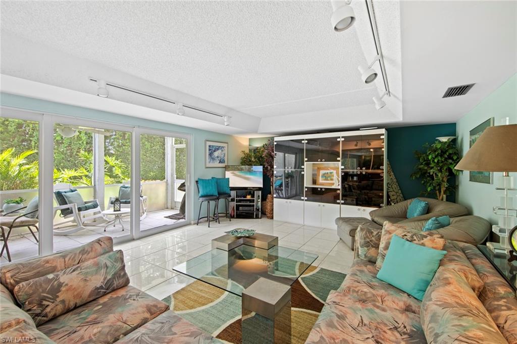 740 Teryl Road, Unit 1 Naples, FL 34112 - Photo 9 of 21 a living room with furniture and large windows