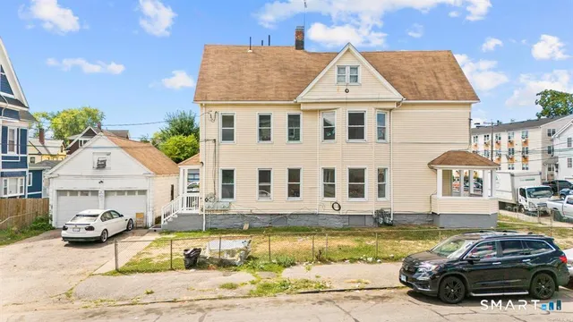 a front view of a house with cars parked