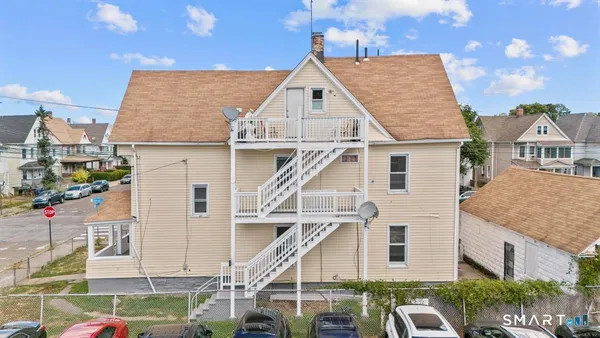 a view of a white house next to a yard