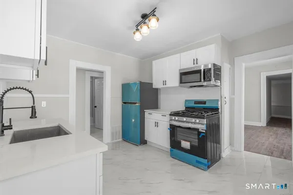 a kitchen with stainless steel appliances granite countertop a stove a refrigerator and a sink