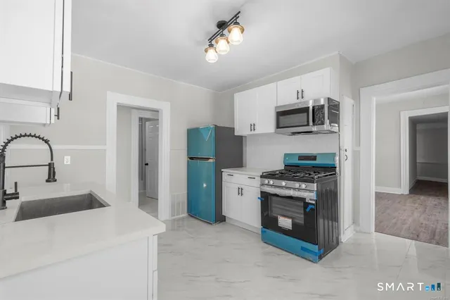 a kitchen with stainless steel appliances granite countertop a stove a refrigerator and a sink