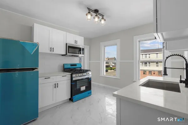 a kitchen with stainless steel appliances granite countertop a refrigerator stove microwave and sink