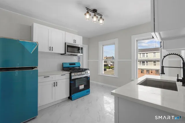 a kitchen with stainless steel appliances granite countertop a refrigerator stove microwave and sink