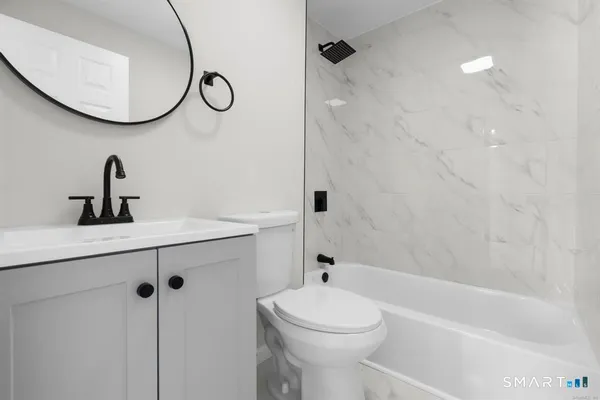 a bathroom with a granite countertop sink a toilet and a mirror