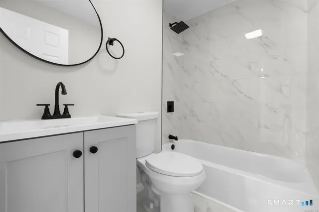 a bathroom with a granite countertop sink a toilet and a mirror