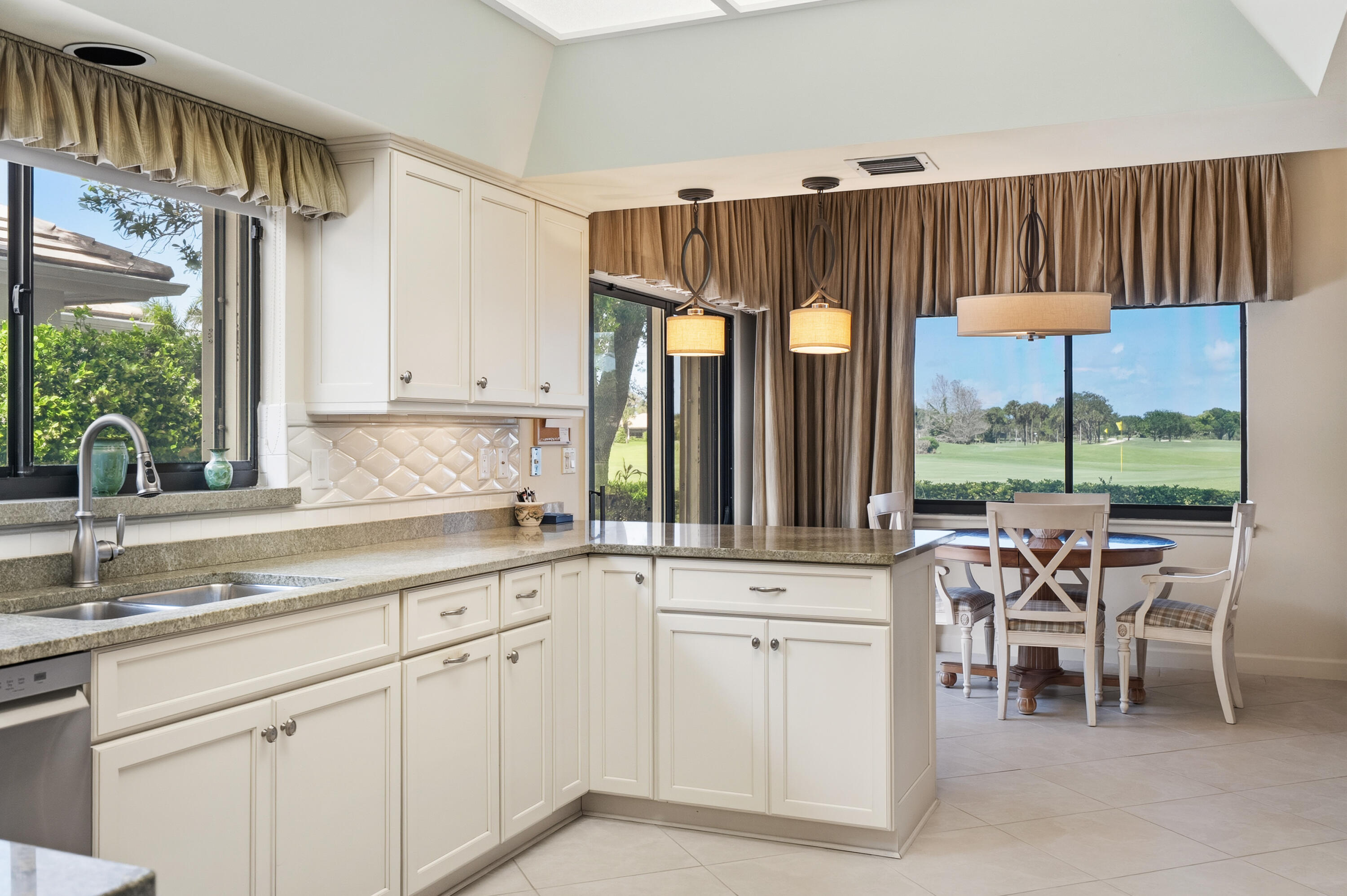 6997 Southeast Pacific Drive Stuart, FL 34997 - Photo 13 of 57 a kitchen with a sink window and chairs