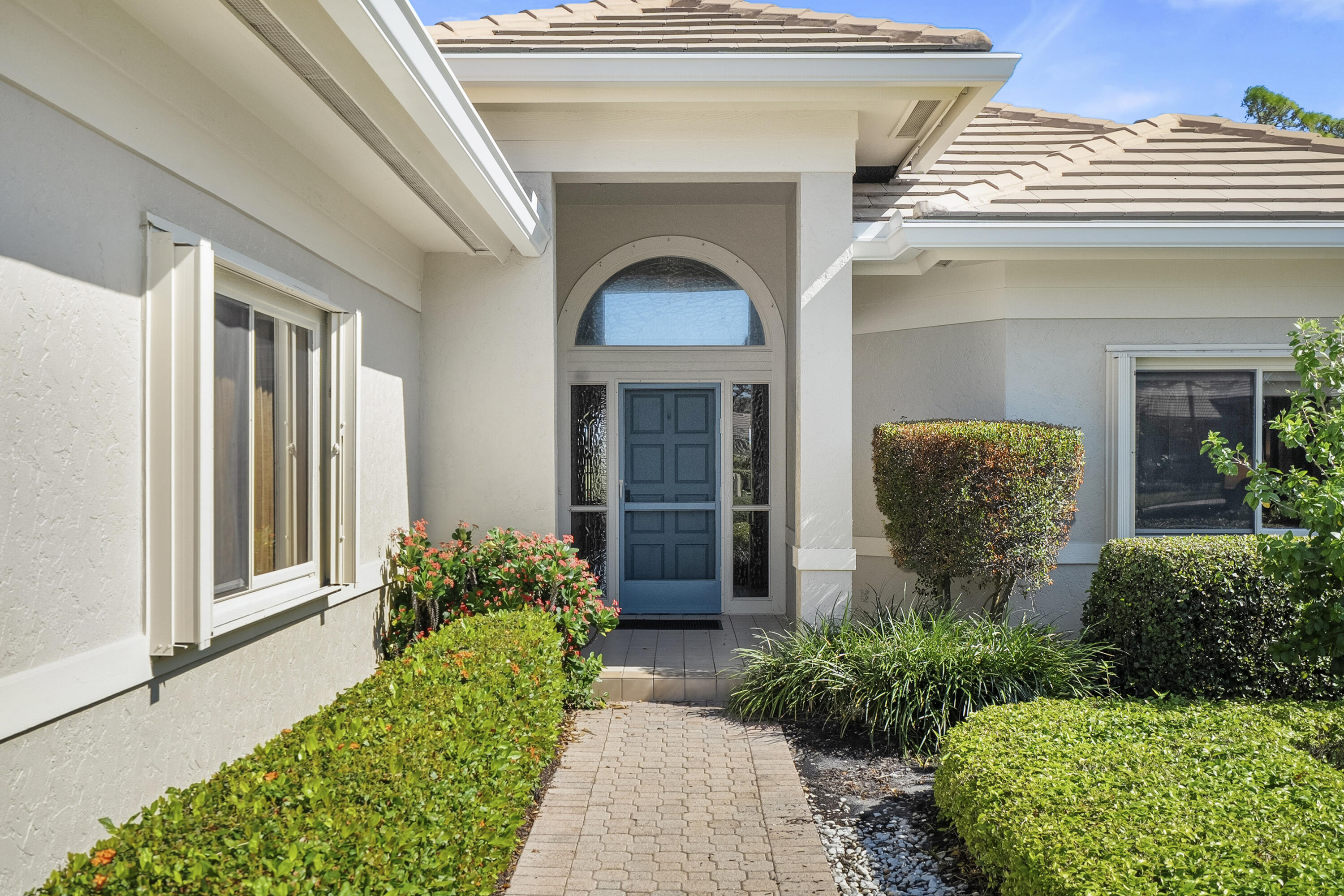 6997 Southeast Pacific Drive Stuart, FL 34997 - Photo 3 of 57 a front view of a house with potted plants