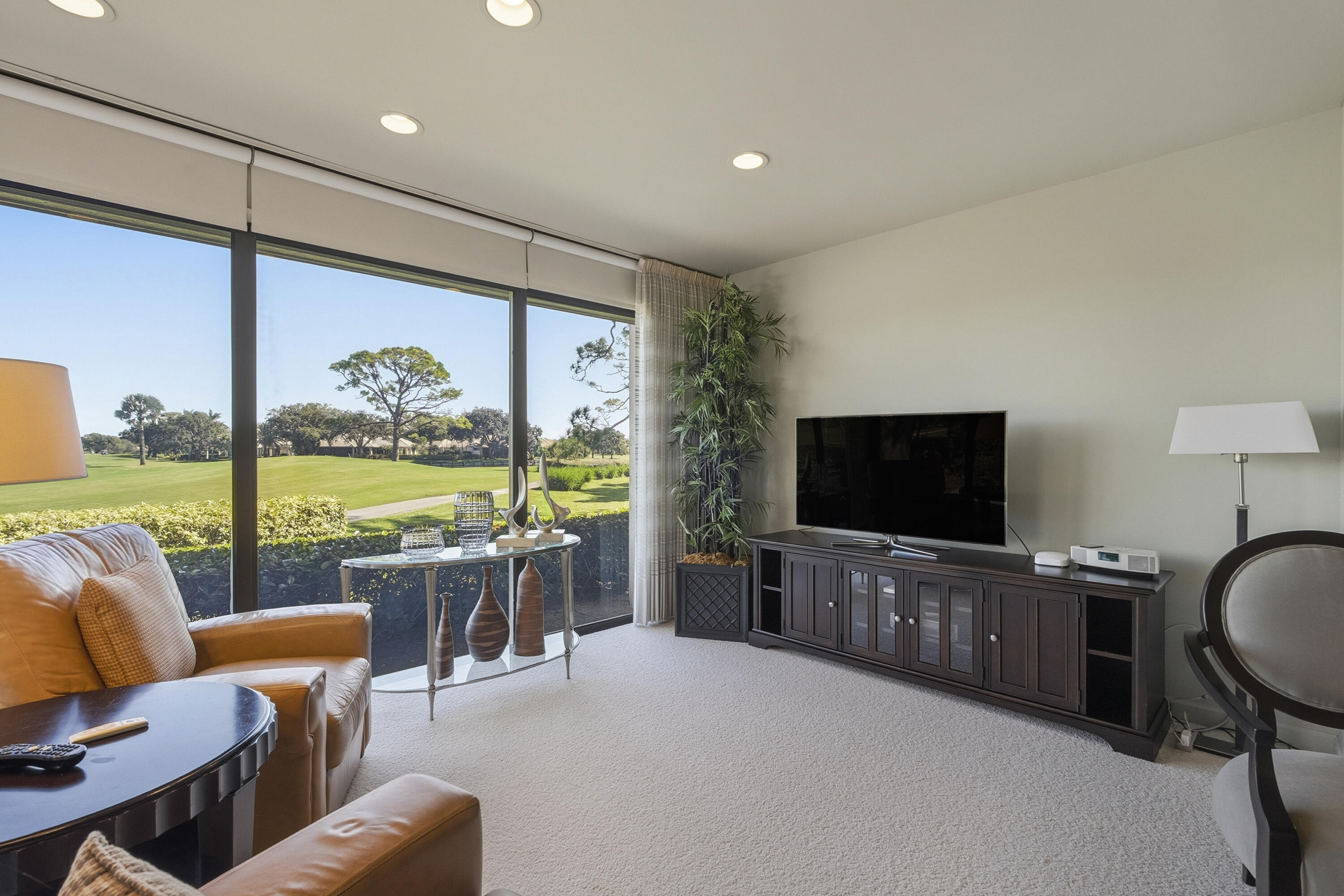 6997 Southeast Pacific Drive Stuart, FL 34997 - Photo 9 of 57 a living room with furniture flat screen tv and a floor to ceiling window