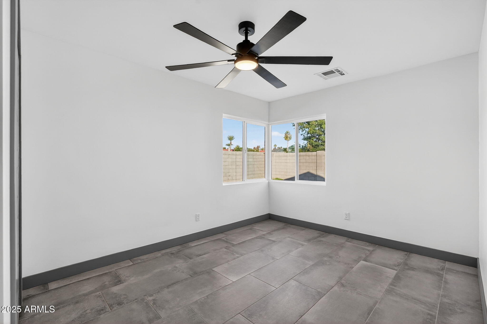 3241 North 27th Place Phoenix, AZ 85016 - Photo 19 of 25 an empty room with ceiling fan and window