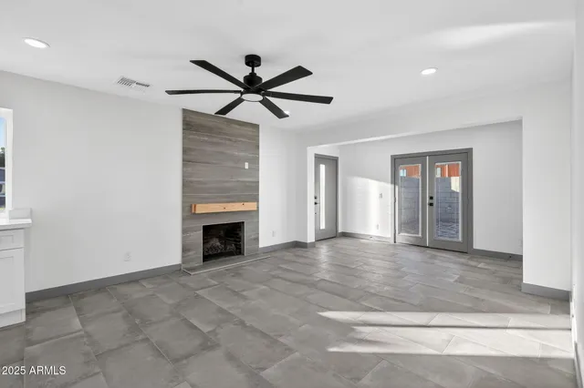 a view of a livingroom with a ceiling fan a fireplace and window