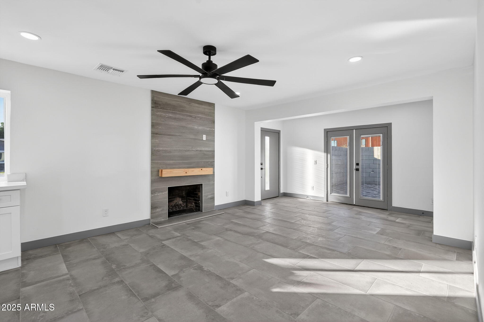 3241 North 27th Place Phoenix, AZ 85016 - Photo 2 of 25 a view of a livingroom with a ceiling fan a fireplace and window