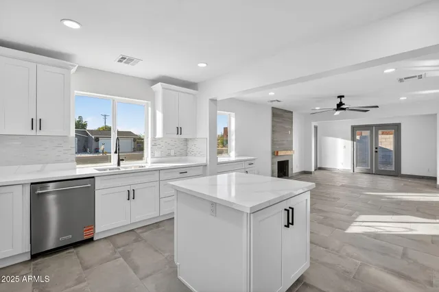 a kitchen with granite countertop a sink and white cabinets