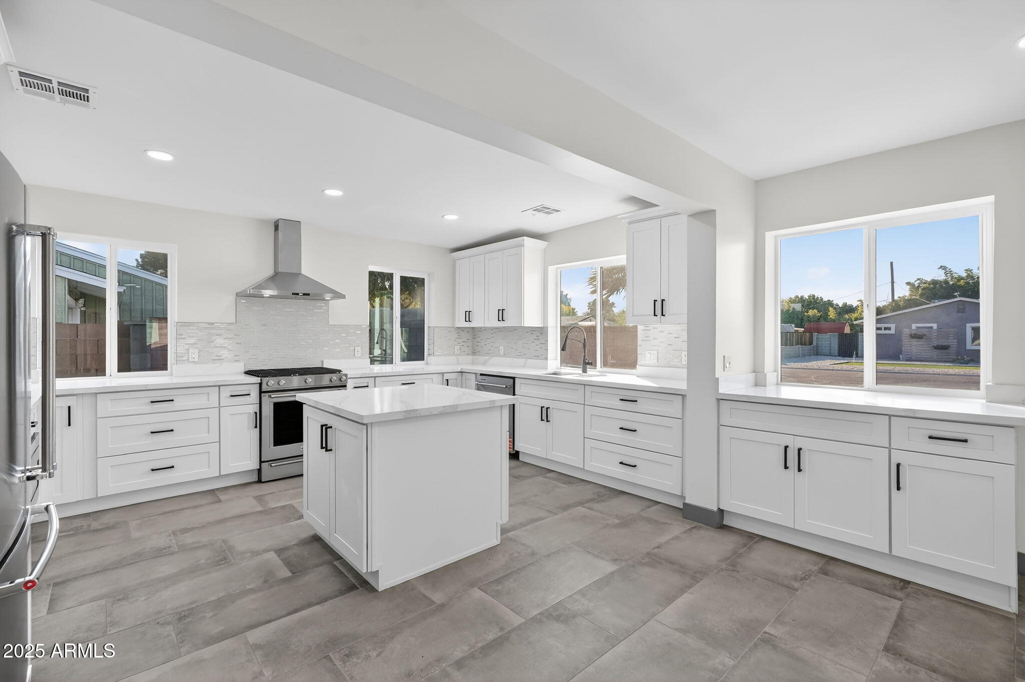 3241 North 27th Place Phoenix, AZ 85016 - Photo 6 of 25 a kitchen with white cabinets and white appliances