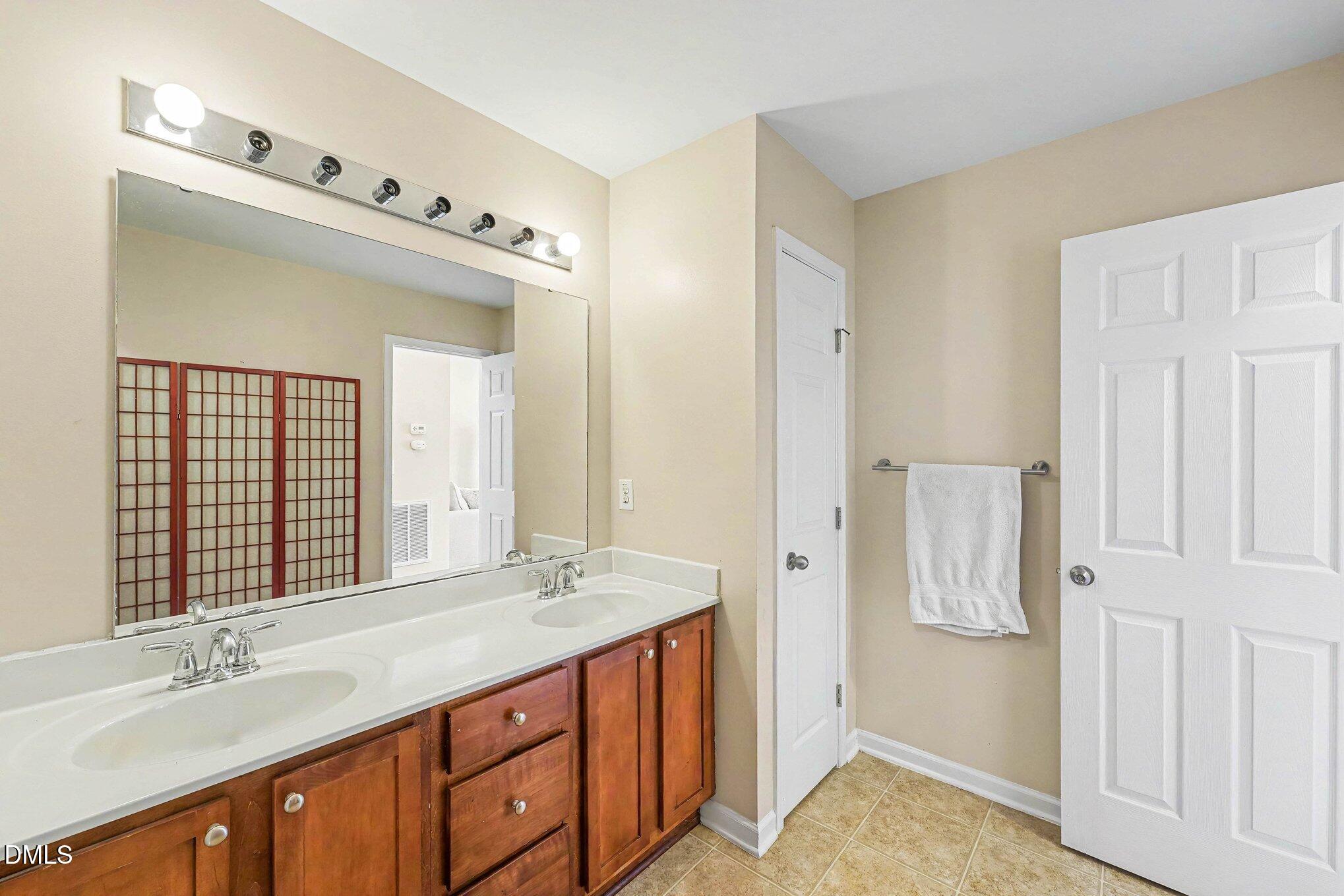 1130 Renewal Place, Unit 106 Raleigh, NC 27603 - Photo 18 of 34 a bathroom with a granite countertop sink and a mirror