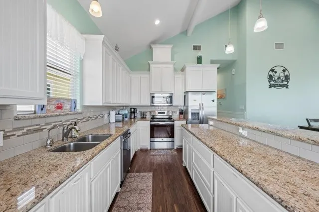 a kitchen with granite countertop a sink stove and cabinets