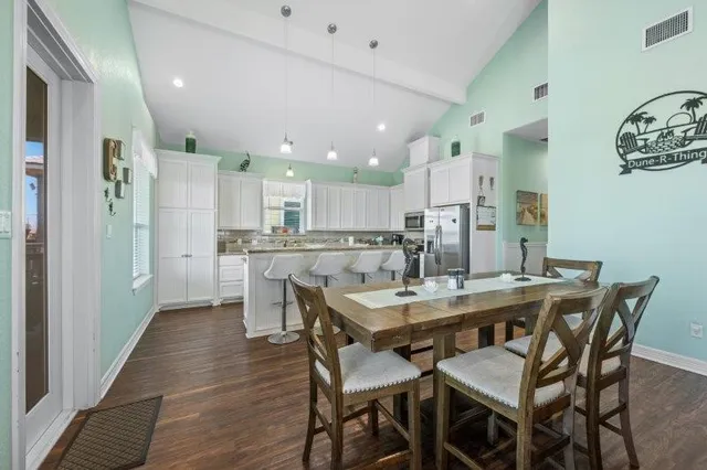 a dining room with stainless steel appliances kitchen island granite countertop a dining table and chairs