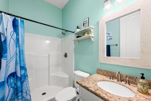 a bathroom with a granite countertop sink toilet and shower