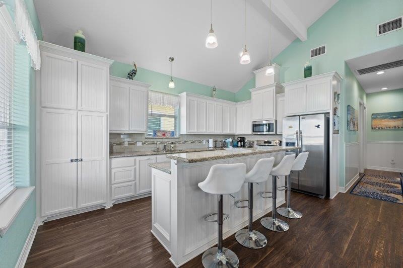 343 Jettyview Road Freeport, TX 77541 - Photo 9 of 44 a kitchen with a refrigerator a white cabinets and wooden floor