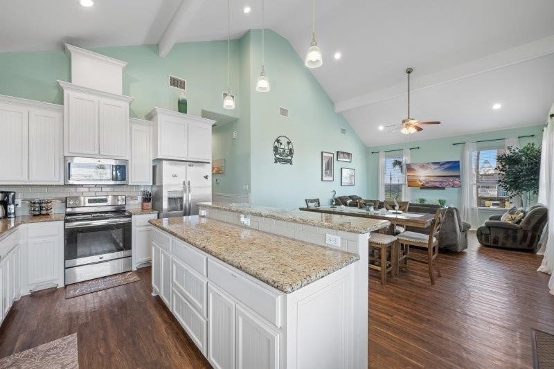 343 Jettyview Road Freeport, TX 77541 - Photo 10 of 44 a kitchen with stainless steel appliances granite countertop a stove top oven a sink dishwasher and a refrigerator with wooden floor