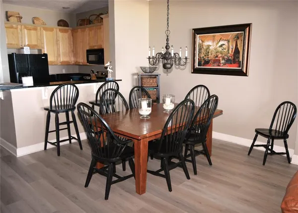 a view of a dining room with furniture a rug and wooden floor