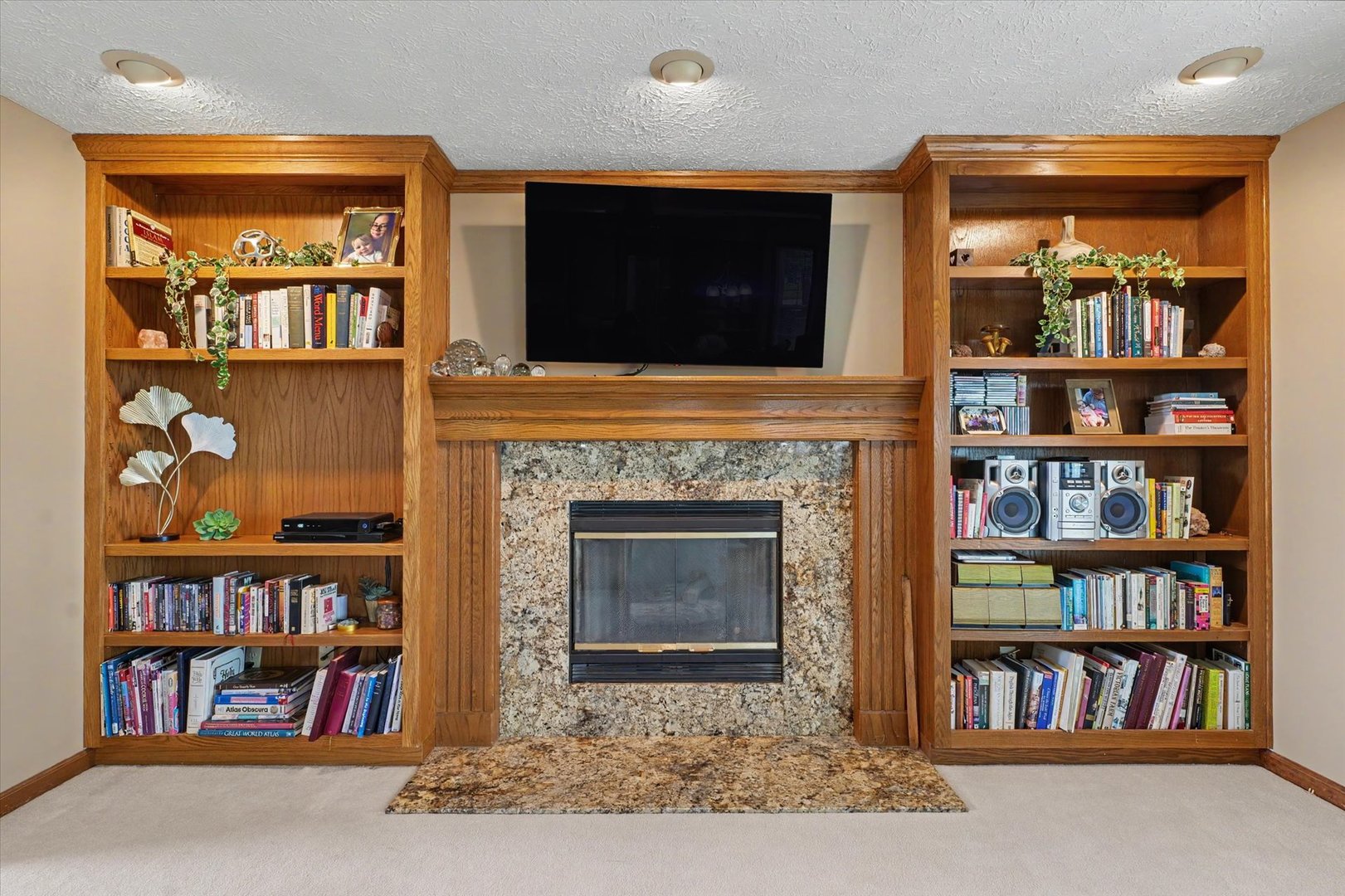 4409 Copper Ridge Road Champaign, IL 61822 - Photo 10 of 40 a living room with lots of books and a fireplace