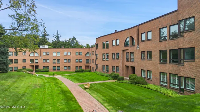 a view of an empty room with wooden floor and fire place