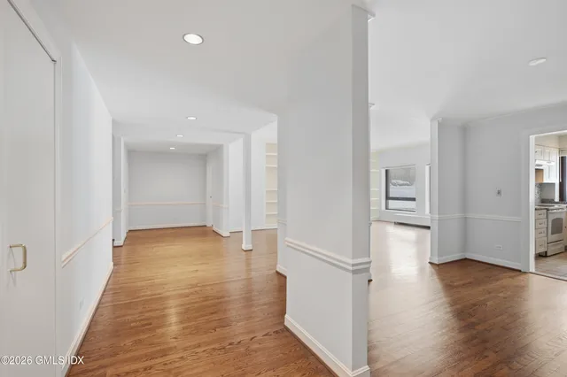 a view of an empty room with wooden floor and closet