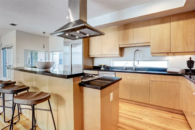 a kitchen with stainless steel appliances granite countertop a sink a stove and a refrigerator