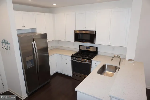 a kitchen with stainless steel appliances a refrigerator stove and sink