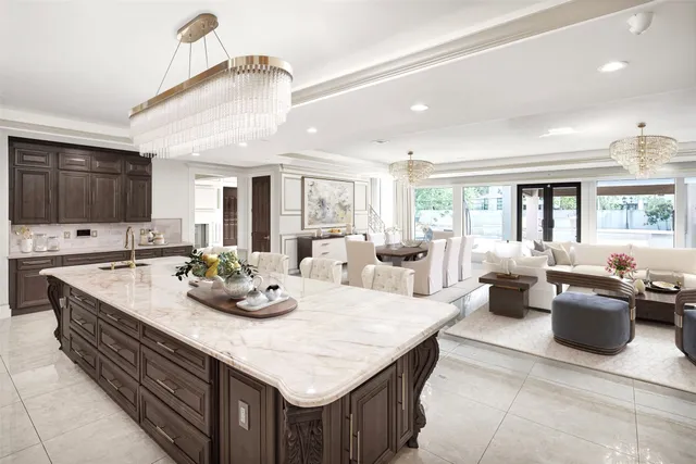 a large kitchen with kitchen island a large counter space appliances and a chandelier