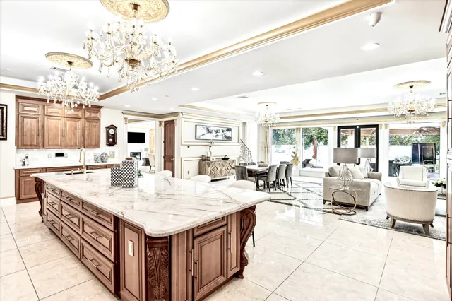 a dining area with stainless steel appliances kitchen island granite countertop a dining table chairs and a refrigerator