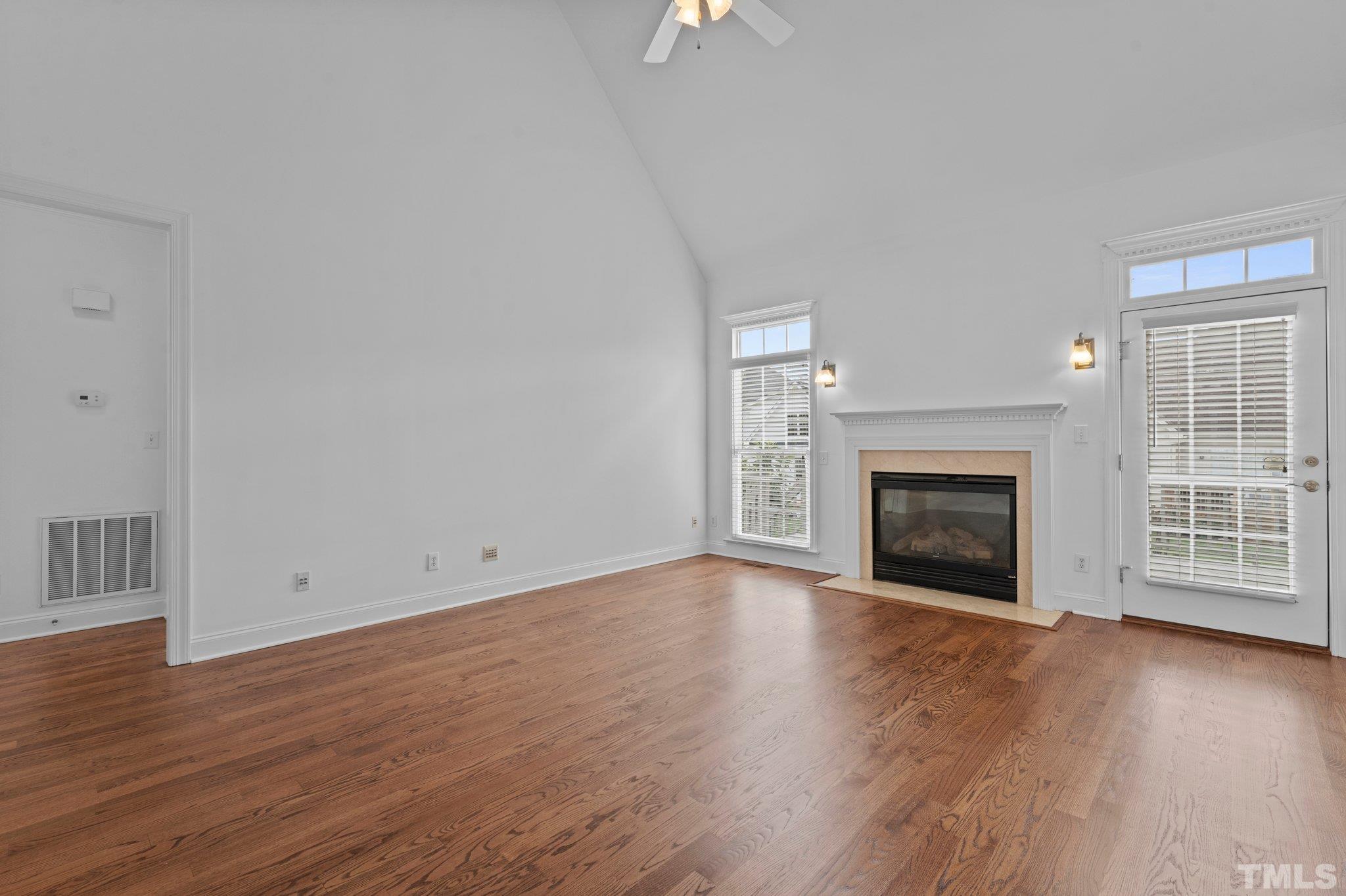 4800 Patton Ridge Court Raleigh, NC 27612 - Photo 40 of 61 an empty room with wooden floor fireplace and windows
