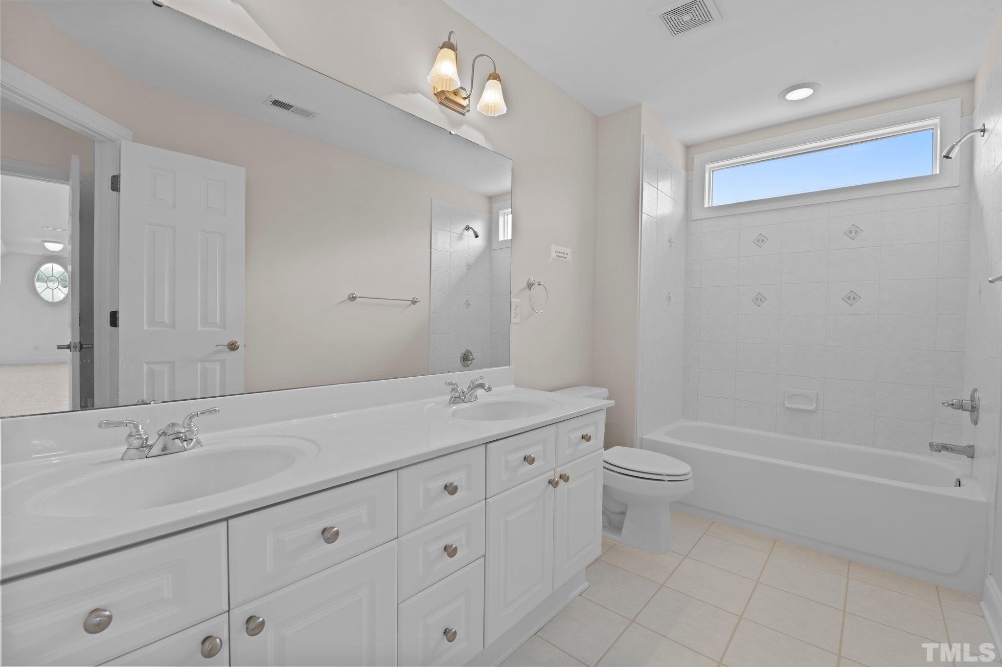 4800 Patton Ridge Court Raleigh, NC 27612 - Photo 59 of 61 a bathroom with a double vanity sink a toilet and a bathtub