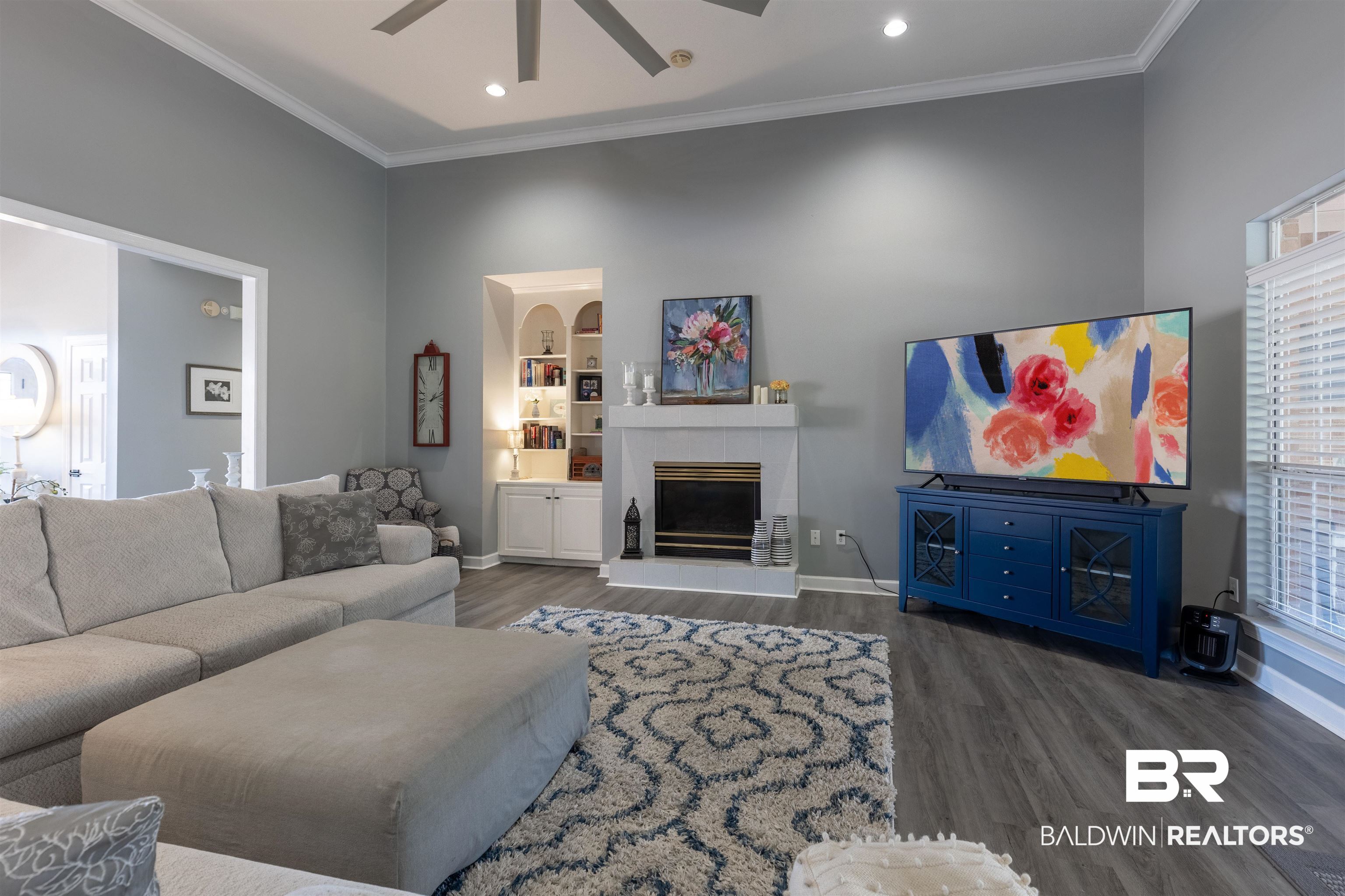 6436 Cherry Ridge Court West Mobile, AL 36695 - Photo 13 of 26 Living area featuring a tile fireplace, crown molding, baseboards, ceiling fan, and dark wood-style floors
