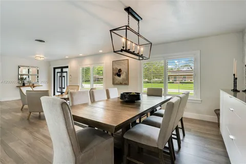 a kitchen with a sink stainless steel appliances wooden floor and a window